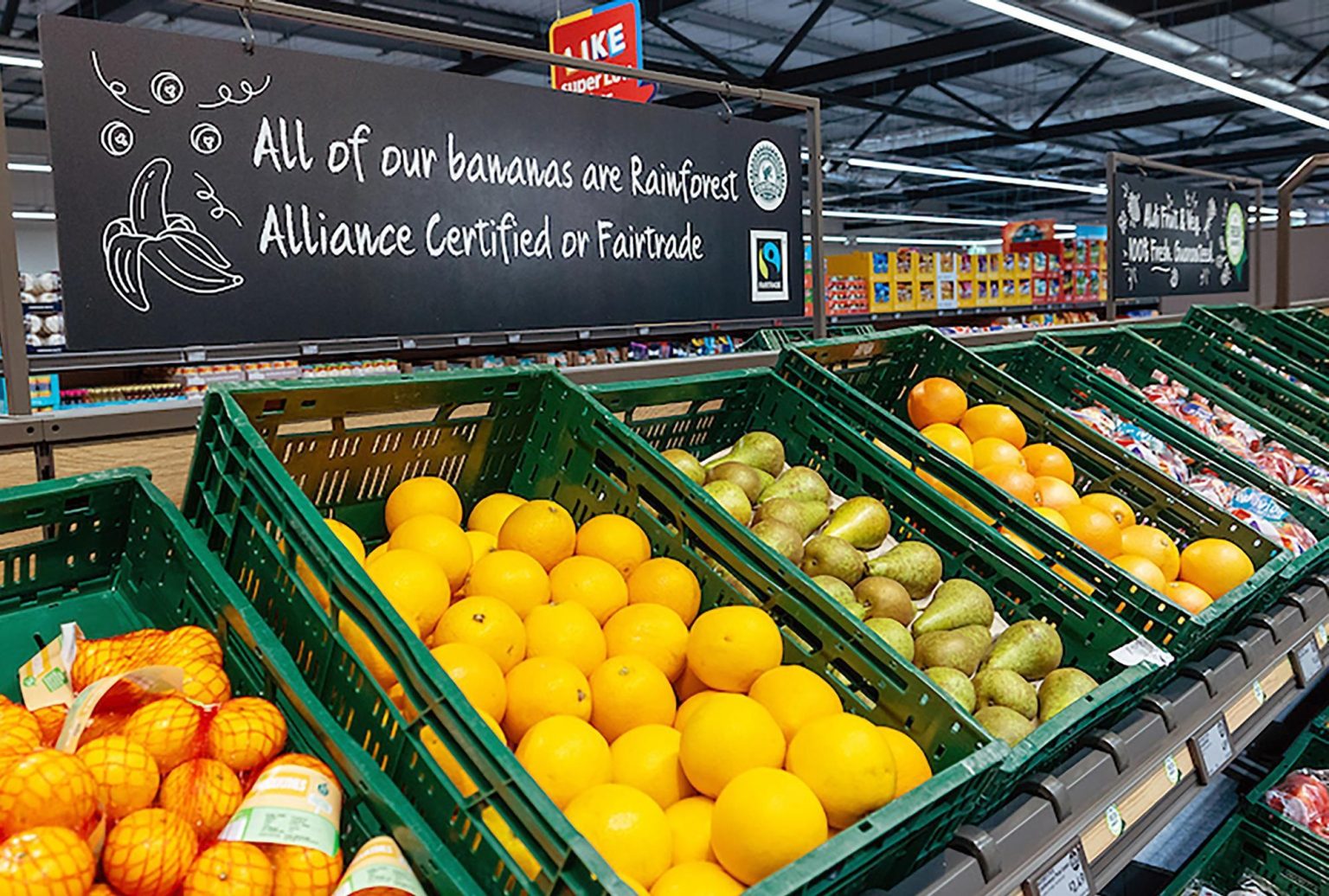 Labeled Aldi Super 6 fresh fruit and vegetable display in a UK retail store. Latest Special Weekly Food Offers