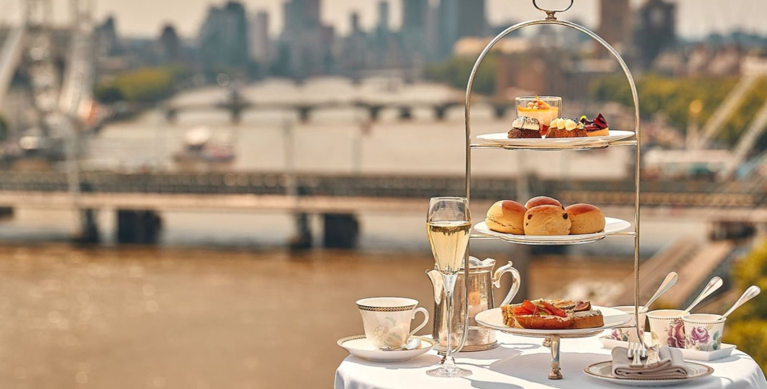 A three-tiered stand with sandwiches, scones, and pastries for the best afternoon tea experiences in the UK.